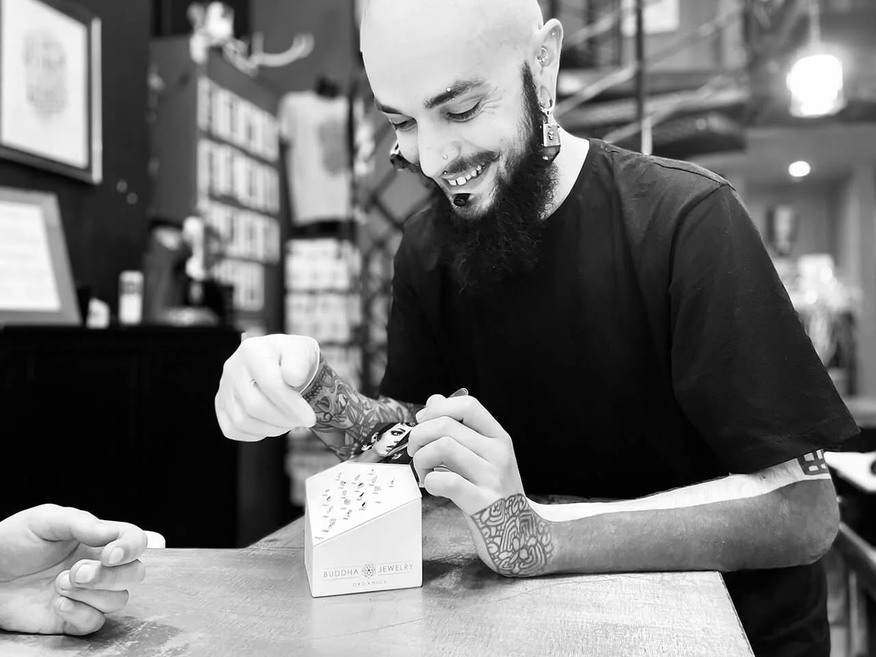 Pierceur présentant une sélection de bijoux de piercing au studio Casa de Leões